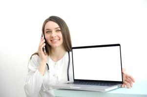 A woman doctor consultant with a laptop on a white background. woman doctor working on the phone answering the call in front of her laptop with white screen space for advertising photo