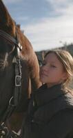 réconfortant connexion. jockey fille dans costume avec amour caresse une cheval à ranch, démontrant se soucier et mode de vie chaleur. haute qualité 4k métrage video