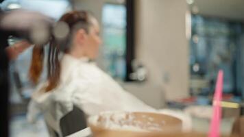 une coiffeur s'applique cheveux colorant à une brosse, fermer. beauté procédures dans une beauté salon. haute qualité 4k métrage video