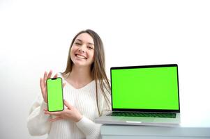 Defocused woman holding out smartphone with green screen, copy space photo