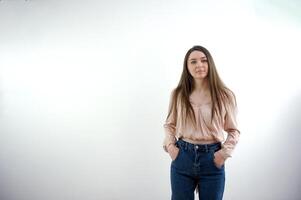 lleno cuerpo cuadro de atractivo niña vestir camisa manos bolsillos pantalones posando para revista mejor diseñador año aislado en azul color antecedentes foto