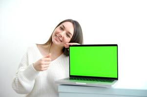 Young woman holding laptop with success photo