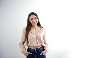Portrait of an elegant young woman in white top and black pants in the studio. photo