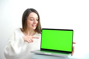 beautiful brunette working with laptop computer smart officer lady in casual wear smile and point her finger on face and use laptop in technology generation photo