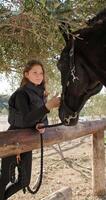 formación en compasión. jockey niña demuestra amor para animales, caricias y cuidando para un caballo a el rancho, estilo de vida calor. alto calidad 4k imágenes video