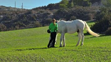 harmonia com natureza. mulher cuidadosamente acariciando e caminhando uma cavalo dentro rancho campo, demonstrando Cuidado e animal amor em fazenda, desfrutando uma pacífico andar com cavalo dentro lindo natural panorama video