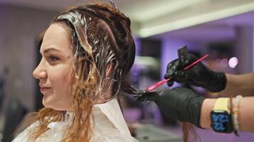 beauté et affaires mélange. femme d'affaires cheveux coloration par professionnel femelle coiffeur dans studio. haute qualité 4k métrage video