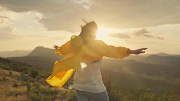 A girl on top of a mountain raises her hands to the mountains. A woman on a hike conquers a mountain range and feels freedom. video