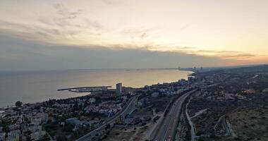 aéreo Visualizações do a paisagem urbana do a subúrbios do Limassol, Chipre. pôr do sol em a Beira Mar em a ilha, arquitetônico e urbano paisagem, montanhas. Alto qualidade 4k cenas video