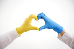 Hands forming a heart in colors of national flag of Ukraine. Isolated on white background with clipping path. photo