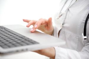 Close-up of female hand touching buttons of white computer keyboard photo