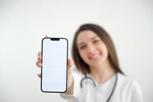 Woman doctor with a smartphone, on a blue background. Place for advertising. Copy paste. healthcare concept. photo