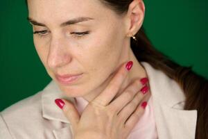 enfermedad, salud cuidado, gente, medicina concepto garganta dolor. de cerca de enfermo mujer con dolorido garganta sensación malo, sufrimiento desde doloroso tragar. hermosa niña conmovedor cuello con mano foto