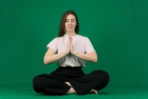 yoga. joven niña va en para Deportes. diferente emociones de un joven niña en un verde antecedentes chromakey hermosa facial caracteristicas real personas rosado camiseta blanco desollado. europeo foto