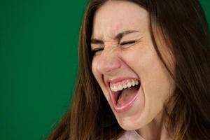 retrato de atractivo hembra modelo en negativo humor. estudio Disparo de morena mujer en histérico ánimo, gritando Gritando en ira y pena. foto