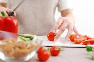 hermosa joven mujer preparando vegetal ensalada en el cocina. sano alimento. vegano ensalada. dieta. dieta concepto. sano estilo de vida. cocinar a hogar. preparar alimento. corte ingredientes en el mesa foto