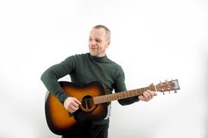 Picture of a guitarist, a man playing a guitar while sitting in a natural garden,music concept photo