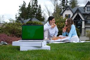 Cheerful african couple eating pizza and having drinks on a date at home photo