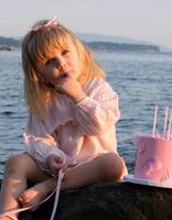 Aristocratic little girl having picnic on the seashore photo