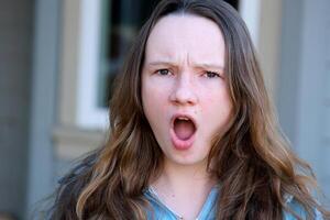 Young female showing emotion of shock, horror and surprise, on white background. UK photo