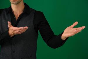 A handsome business man in a suit stands in full growth isolated on a green background. photo