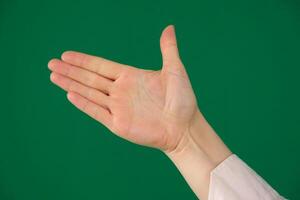 a raised five fingers, hand symbol, viewed from front isolated on green background. photo