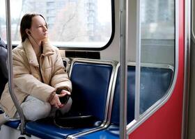 joven niña adolescente paseos en transporte mira fuera el ventana brillante casas de cerca calma pacífico cara espacio para texto cielo tren autobús coche ordinario persona en real vida calle ciudades Vancouver suburbio foto