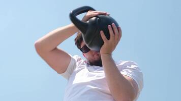 gli sport e tempo libero. forte caucasico uomo Lavorando su utilizzando kettlebell nel il parco video