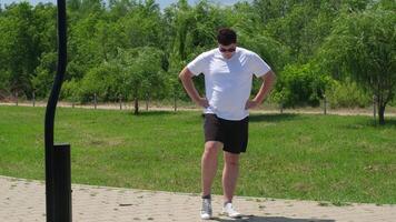 Deportes y ocio. fuerte caucásico hombre trabajando fuera utilizando pesas rusas en el parque video