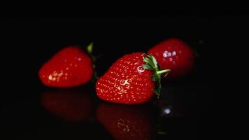 frisch saftig schön Erdbeere auf ein schwarz Hintergrund im das dunkel video