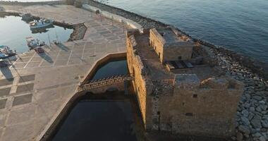 aéreo Visão do antigo castelo forte em a Mediterrâneo costa dentro pafos, Chipre, mostrando a lindo histórico pedra construção e paisagem urbana. Alto qualidade 4k cenas video