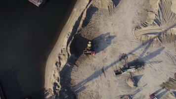 Aerial top view of trucks and machinery in the sand quarry. Scene. Sand pit, loading wagon sand, concept of heavy industry. video