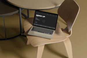 Laptop mockup on the chair with realistic table background psd