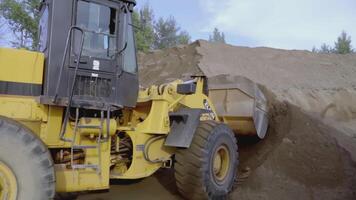 Reino Unido, Londres - marzo 21, 2022. un excavador ascensores arena desde un cantera. escena. siguiente a el excavador es un kamaz. arena es minado en un cantera. en el antecedentes es un lago en un cantera video