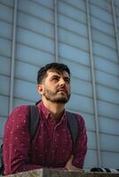 Urban Chic Stylish Man with Black Backpack and Glasses in Cityscape photo