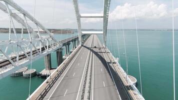 Huge bridge. Drone view. Action. A long bridge over the ocean on which cars can move freely, the bridge is located next to the green mountains video