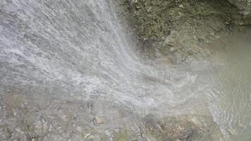 Mountain waterfall. Action. Thin streams with drops of water run over mountain rocks and fall down. video