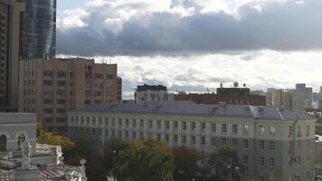 The view from the drone. View of the center of Yekaterinburg. Stock footage. Gloomy sky over the city with huge buildings next to the tallest building with the name Vysotsky in the very center of the video