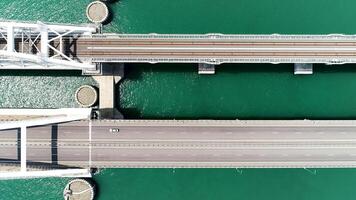 ein enorm Brücke ist ein Vogelaugen Sicht. Aktion. ein lange Neu Brücke gebaut zum das Bewegung von Transport Über das groß Meer. video