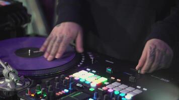 DJ spinning record at disco. Art. Close-up of DJ's hand on mixer. Glowing music panel at party. Musician's work in nightclub video