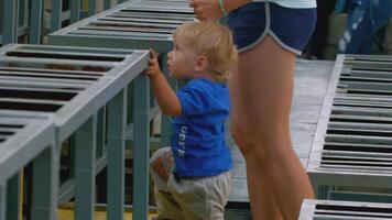 Side view of a little boy child with his young mother climbing up the stairs in the street. Creative. City amphitheater. video