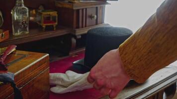 Close up of man in classic clothes putting on satin gloves. Stock footage. Retro background with antiques. video