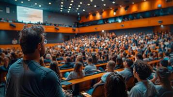 Man Sitting In Front Of Packed Auditorium photo