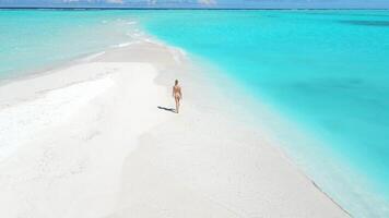 Woman in swimsuit walk on sandbank beach with turquoise ocean water. Drone view with woman in tropical paradise video