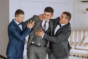 Three men in suits are hugging each other photo