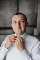 A man is getting ready to go out and is adjusting his tie photo