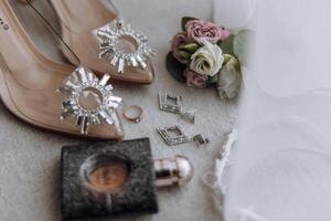 A pair of high heels with a crystal design on the toe and a ring on the finger photo