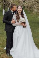 A bride and groom are posing for a picture in a field photo