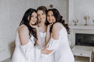 Three women in white dresses are posing for a picture photo