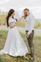 A bride and groom are standing in a field photo
